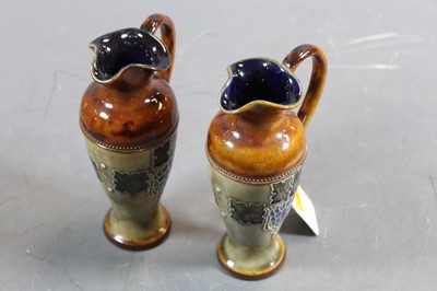Lot 247 - A pair of Royal Doulton miniature ewers, with...