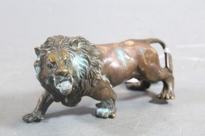 Lot 270 - A patinated bronze model of a prowling lion,...