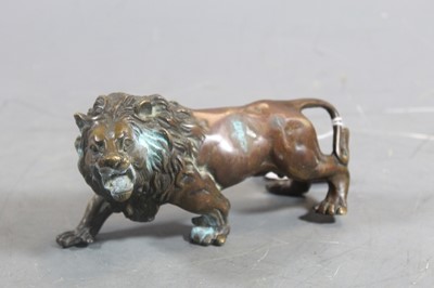 Lot 270 - A patinated bronze model of a prowling lion,...