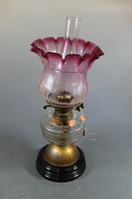 Lot 150 - A 19th century glass oil lamp, the cranberry...