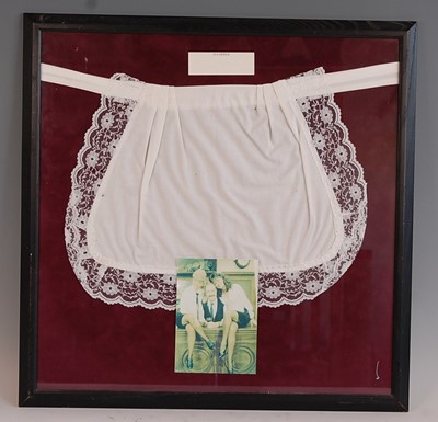 Lot 647 - A white cotton apron with lace trim, mounted...