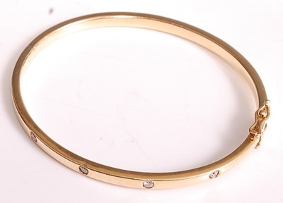 Lot 1099 - An 18ct yellow gold oval hinged diamond bangle,...
