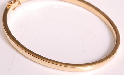 Lot 1099 - An 18ct yellow gold oval hinged diamond bangle,...