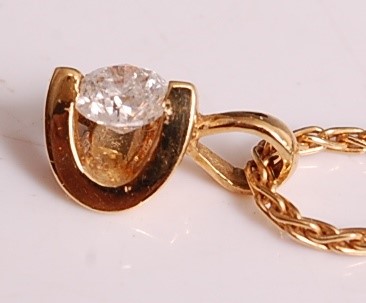 Lot 1102 - An 18ct yellow gold abstract diamond pendant,...