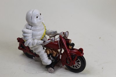 Lot 23 - A cast iron model of the Michelin Man riding a...