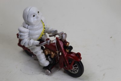 Lot 23 - A cast iron model of the Michelin Man riding a...
