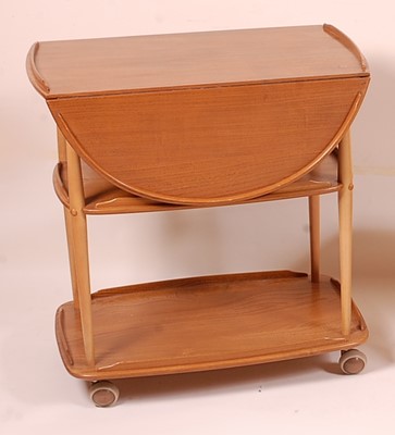 Lot 405 - An Ercol light elm dropflap three-tier tea...