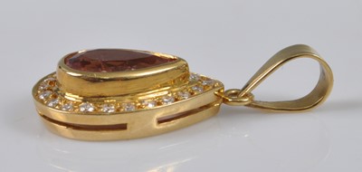Lot 1126 - A yellow metal, topaz and diamond pear-shaped...