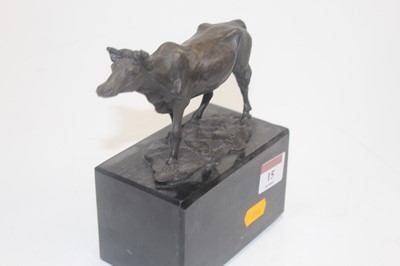 Lot 15 - A modern bronzed metal model of a cow raised...