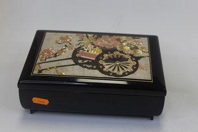Lot 40 - A black lacquered musical jewellery box, the...
