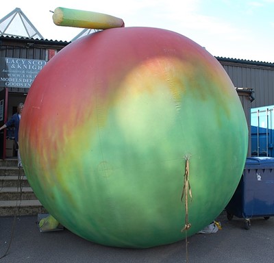 Lot 703 - A large inflatable apple with emerging worm,...