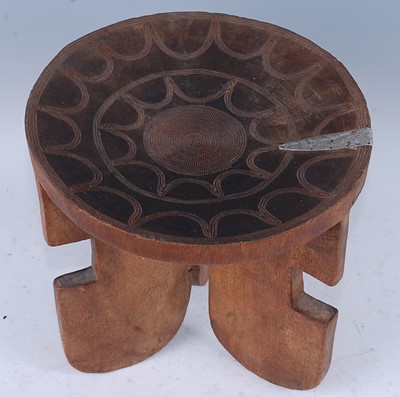 Lot 156 - An African hardwood stool, the dished seat...