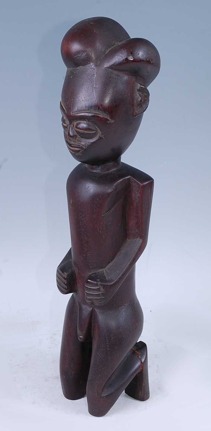 Lot 177 - A wooden ancestor figure, carved in kneeling...