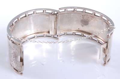Lot 2569 - A white metal oval hinged cuff bangle, half...