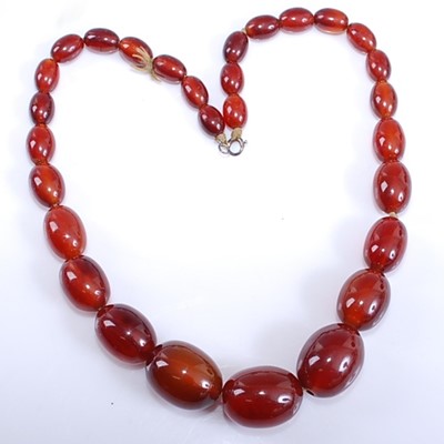 Lot 2576 - A single row graduated cherry amber necklace,...