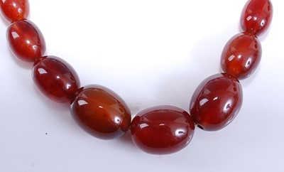 Lot 2576 - A single row graduated cherry amber necklace,...
