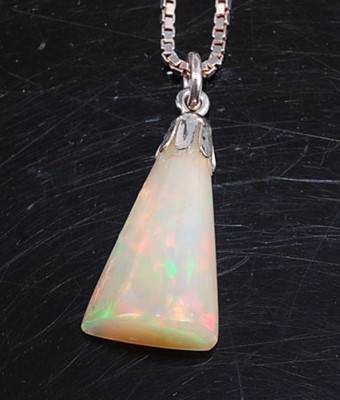 Lot 2577 - An abstract opal pendant, measuring 20 x 12mm...