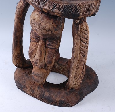 Lot 204 - A ritual stool, carved as a male figure in...