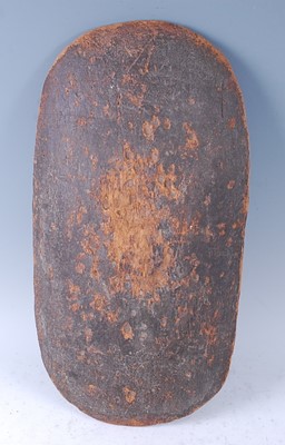 Lot 325 - A carved wooden parrying shield, of domed oval...