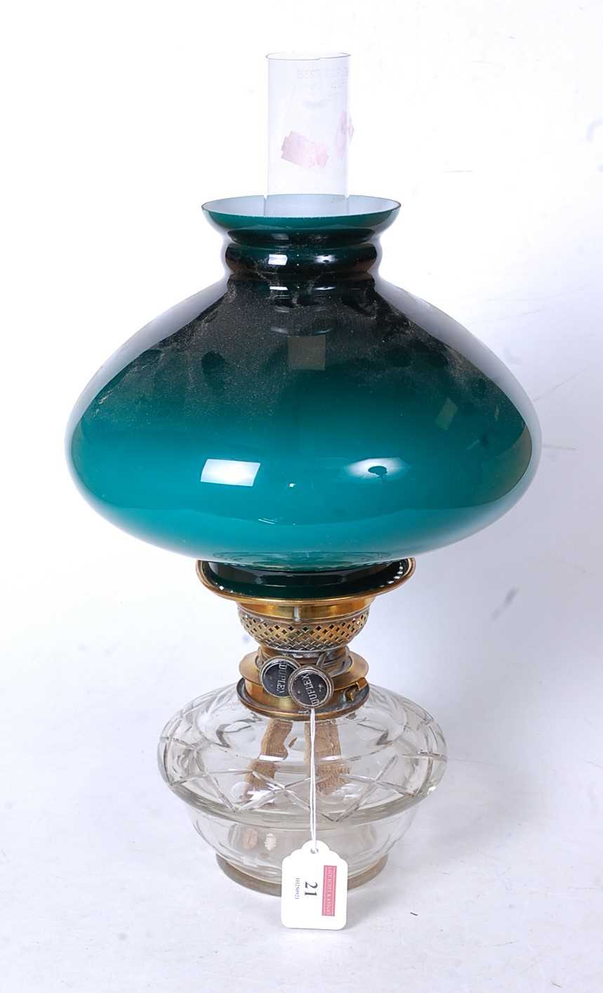 Lot 21 - An early 20th century oil lamp, having a green...
