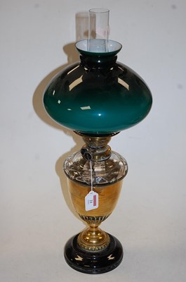 Lot 21 - An early 20th century oil lamp, having a green...