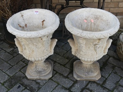 Lot 1147 - A pair of reconstituted stone pedestal urn...