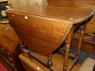 Lot 1226 - A 1930s oak drop leaf table having a gateleg...