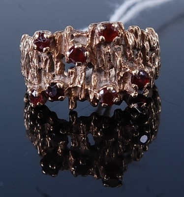 Lot 390 - A modern yellow metal garnet set dress ring,...