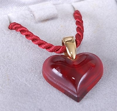 Lot 417 - A Lalique cranberry glass heart shaped pendant...