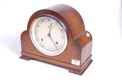 Lot 14 - A 1930s oak cased eight-day mantel clock, the...