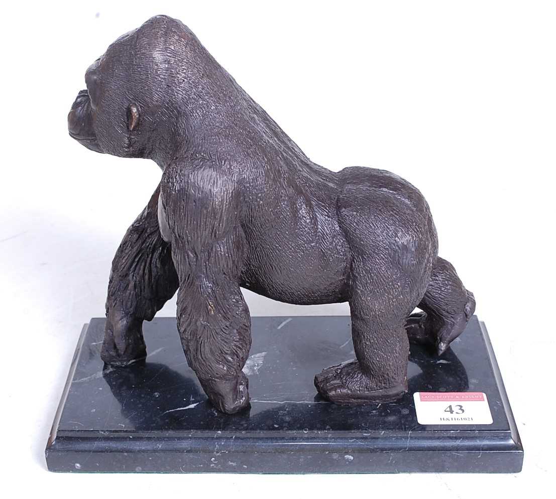 Lot 43 - A bronzed model of a gorilla, walking on all...