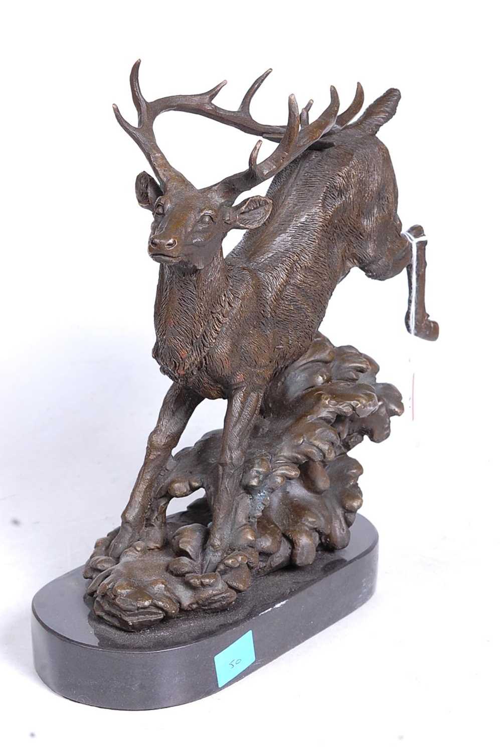 Lot 47 - A bronze model of a running stag, upon a...