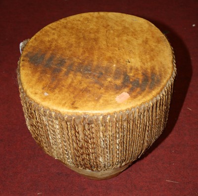 Lot 175 - An African cow hide clad drum, 30cm wide,...