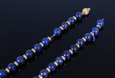 Lot 2724 - A lapis and yellow rondel necklace, comprising...
