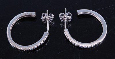 Lot 2774 - A pair of white metal diamond set half hoop...