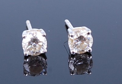 Lot 2786 - A pair of white metal diamond ear studs, the...