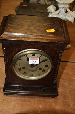 Lot 102 - A 1920s oak cased mantel clock, having a...