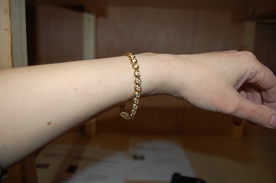 Lot 2332 - An 18ct yellow gold diamond line bracelet,...