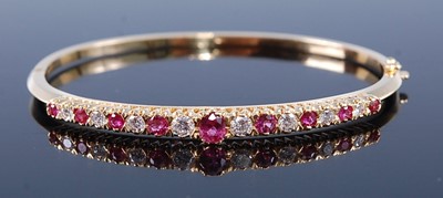 Lot 2320 - A yellow metal, ruby and diamond oval hinged...
