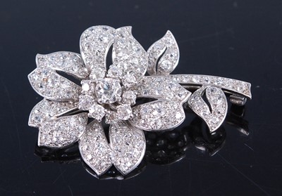 Lot 2344 - A white metal diamond stylised flower brooch,...