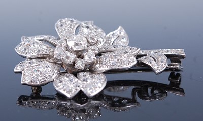 Lot 2344 - A white metal diamond stylised flower brooch,...