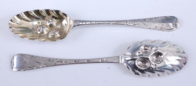 Lot 2080 - A near-pair of George II silver berry spoons,...