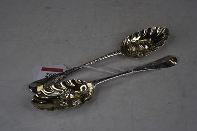 Lot 268 - A near-pair of George II silver berry spoons,...