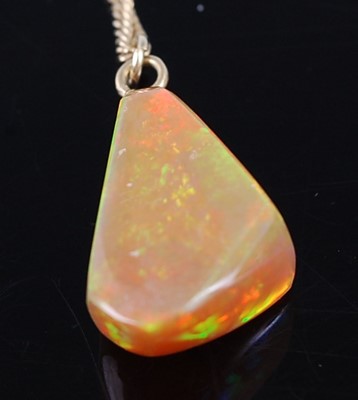 Lot 2361 - A polished opal pendant, of irregular...