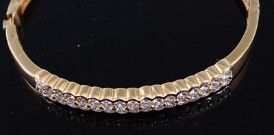 Lot 2380 - A yellow metal diamond set hinged bangle,...