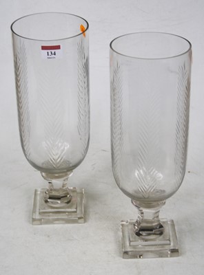 Lot 134 - A pair of glass storm lamps, each having a...