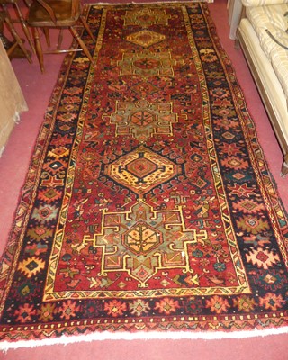 Lot 1147 - A Persian Heriz red ground hall runner, 338 x...