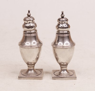 Lot 352 - A pair of George V silver pedestal pepperettes...