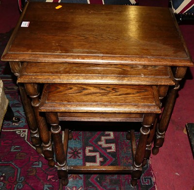 Lot 1445 - An oak nest of three occasional tables, the...