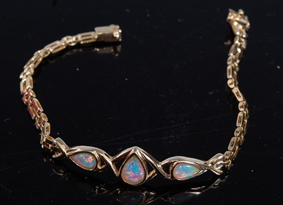 Lot 2169 - A yellow metal opal bracelet, comprising three...